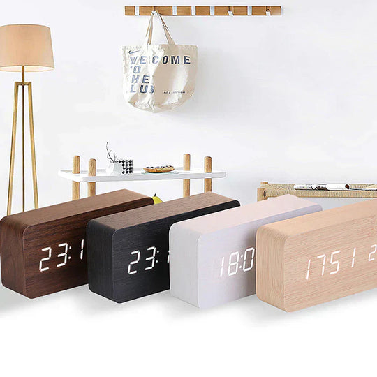 Set of four wooden digital clocks in different colors displaying various times.